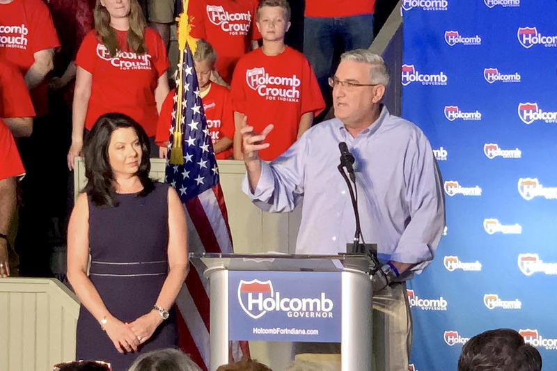 Gov. Holcomb stands next to his wife, Janet, and speaks at a podium at his re-election campaign launch, July 2019.