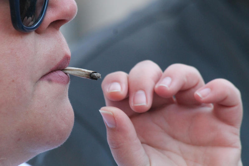 Marijuana advocates smoke outside the Statehouse