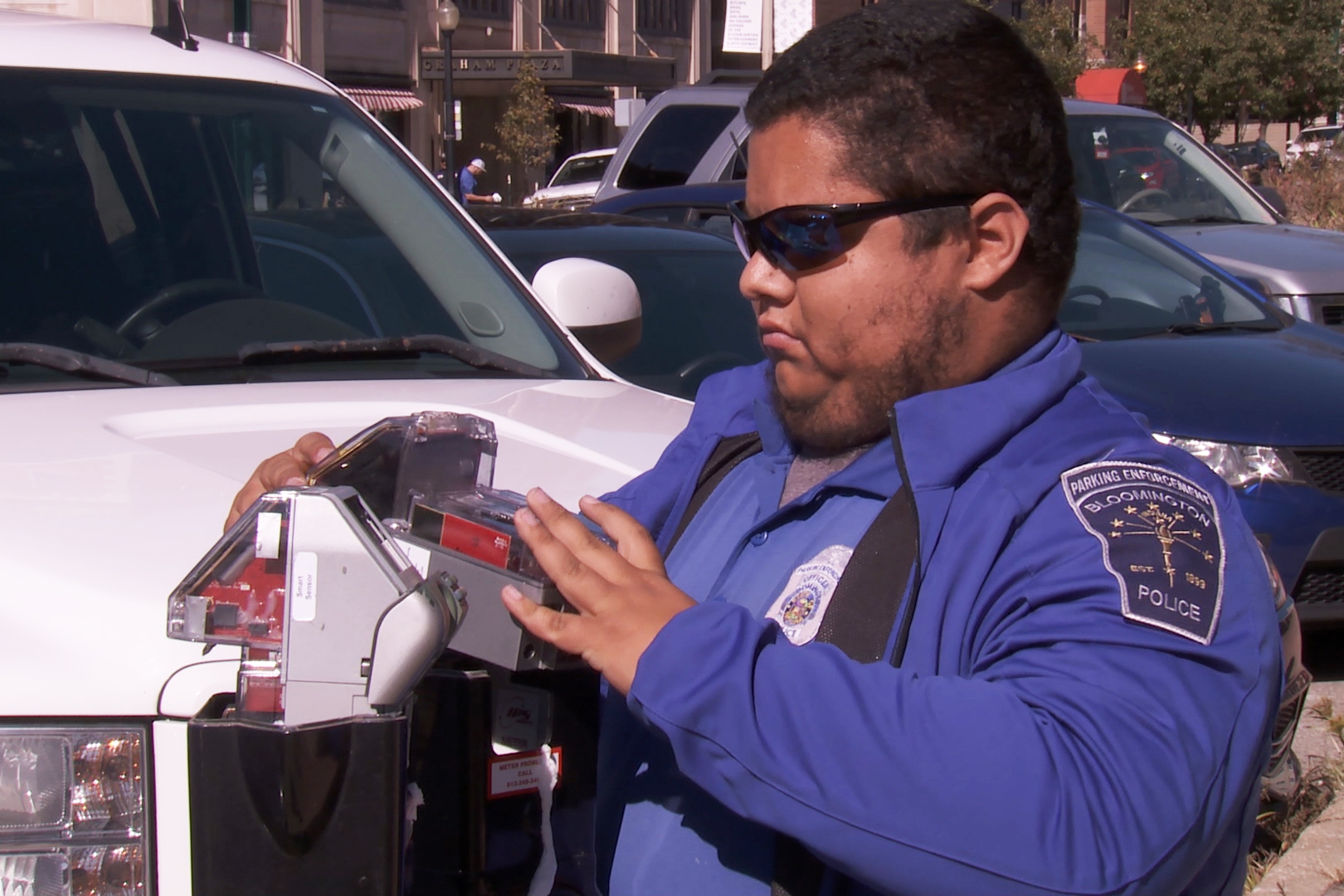 A city employee fixes a parking meter after many were vandalized, Oct. 23, 2019.