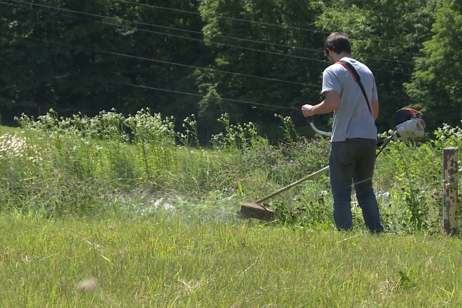 worker weed eating at neals landfill