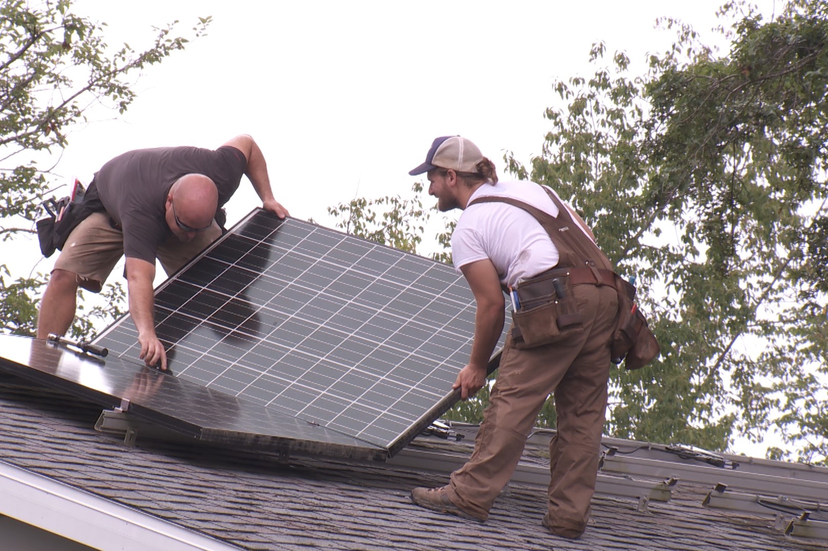 Men install solar panels on Bloomington home