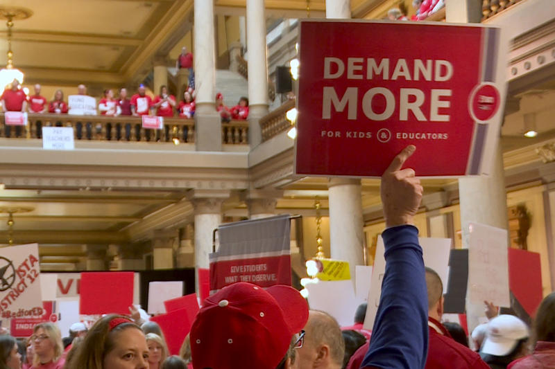Rally attendees hold signs, one reading 'Demand more for kids & educators,' at a rally at the Indianapolis Statehouse in March 2019.