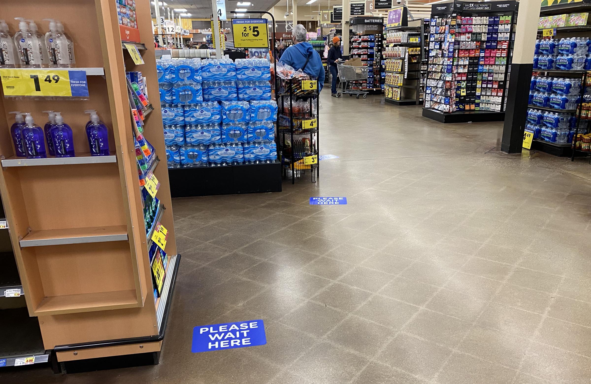 Stickers on the floor of a Kroger in Bloomington, Indiana, show how far apart customers should stand in checkout lines