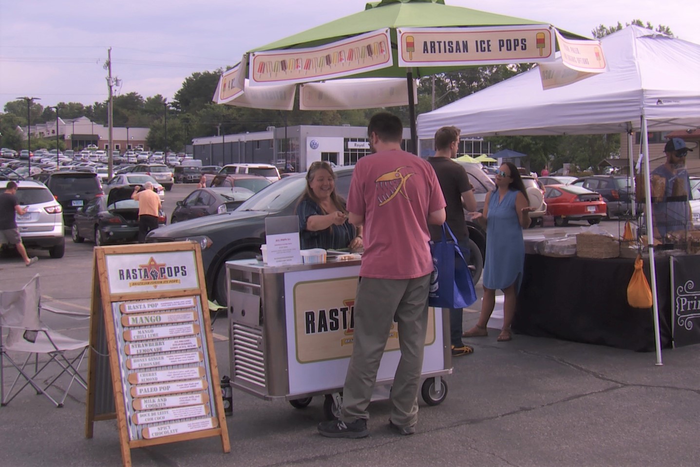 Linda Lewis interacts with a customer at her Rasta Pops cart at 'Hate-Free Farmers Market,' Aug. 17, 2019.