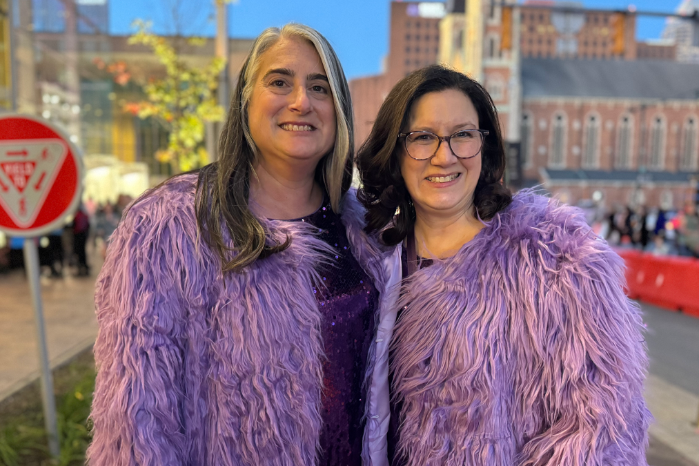 Two women wearing furry purple coat