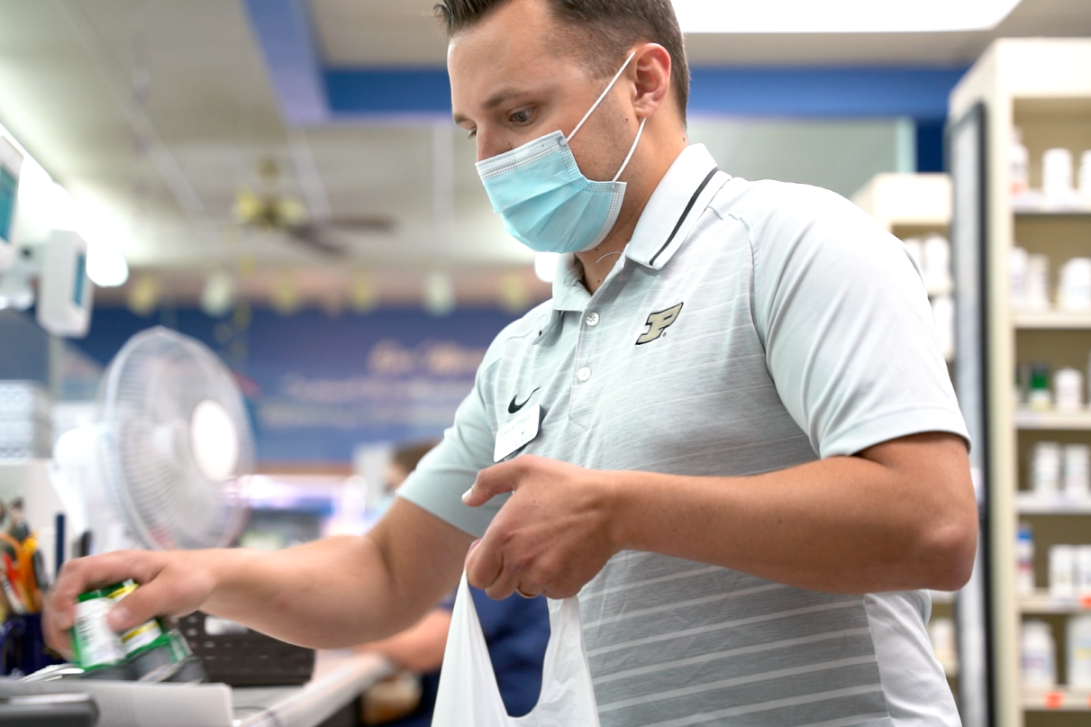 pharmacist filling a bag for customer