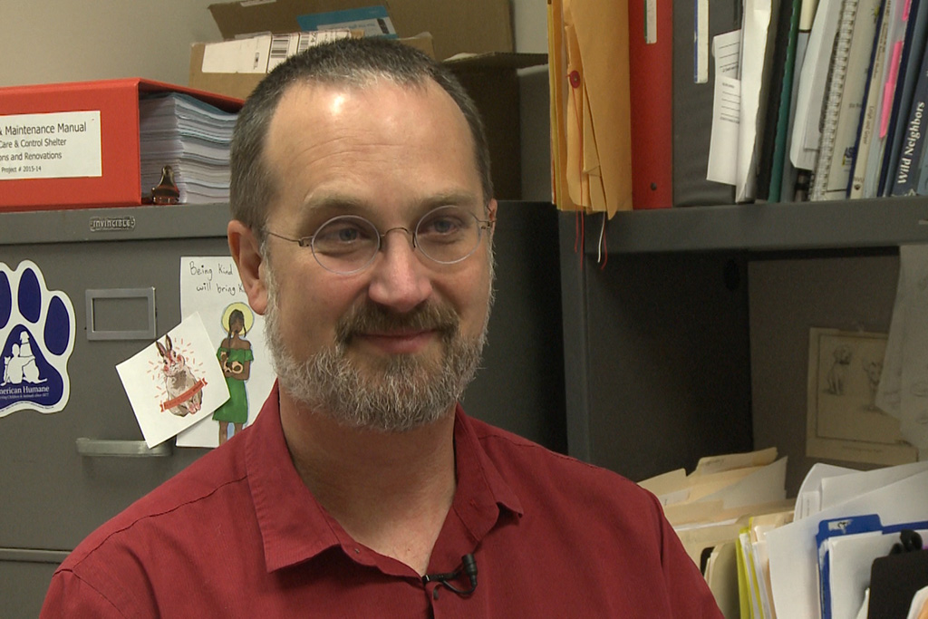 Virgil Sauder sits at desk at animal shelter