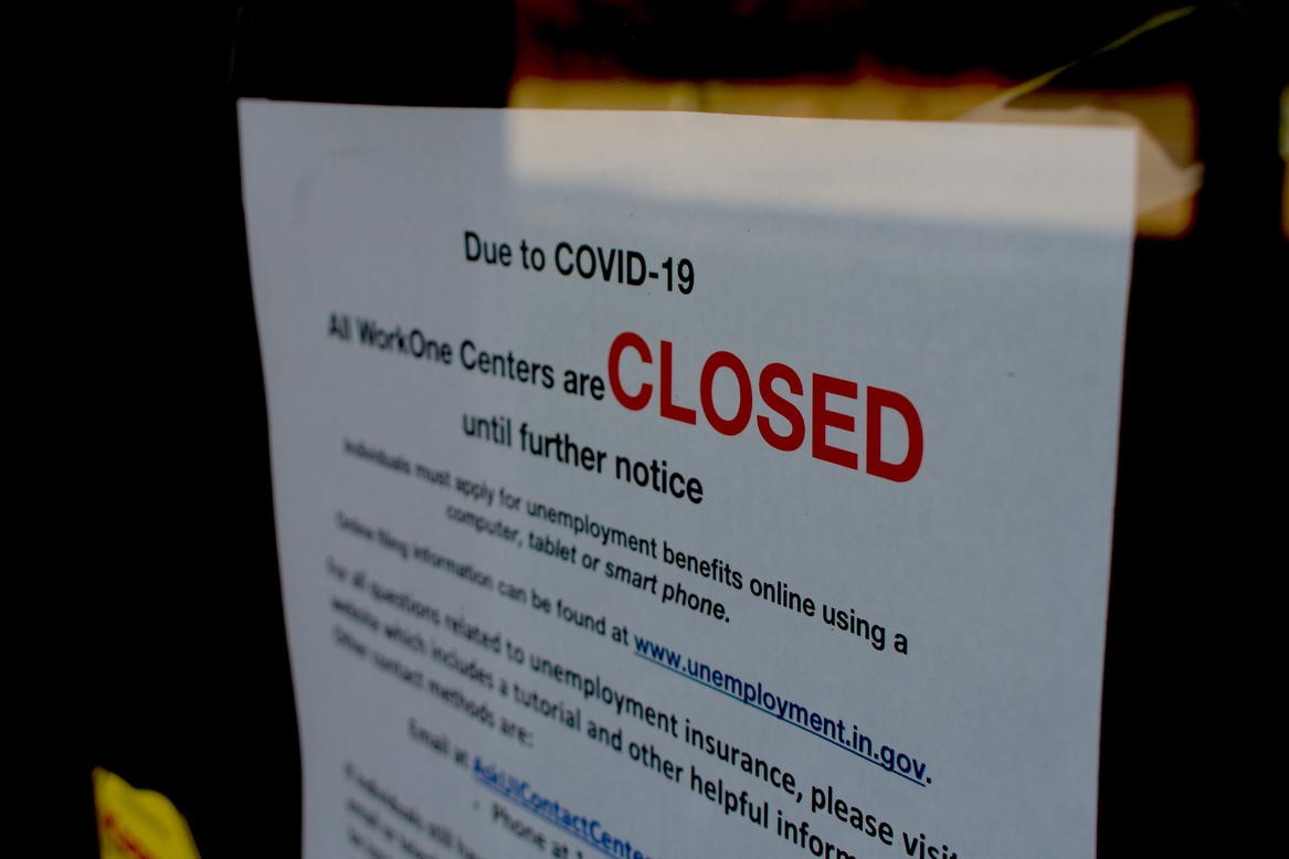 A local WorkOne employment office displays a sign on the front door saying it's closed due to COVID-19.