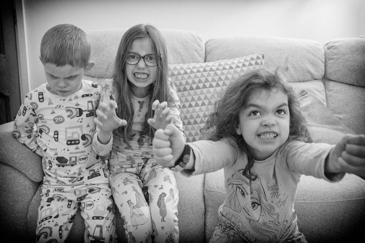 Three kids in their pjs, looking at the camera and making angry faces