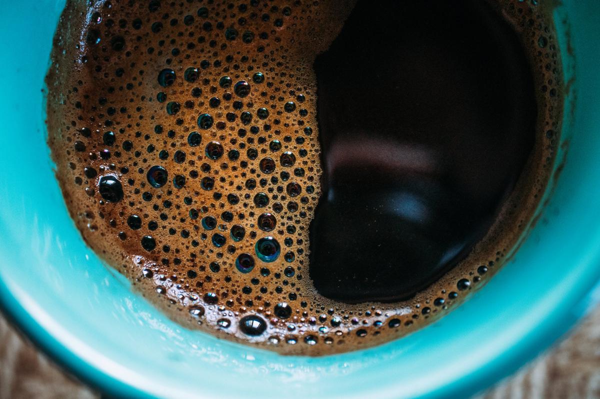 A closeup of black coffee in a blue mug