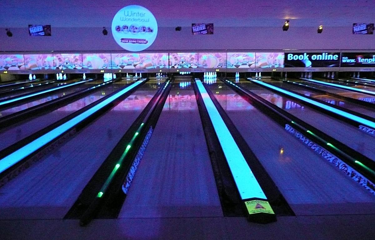 Lanes of a bowling alley light up with blue light