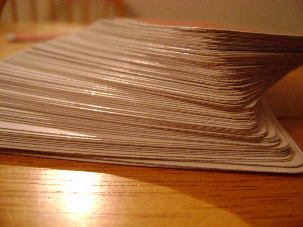 A stack of playing cards facedown on a wooden table