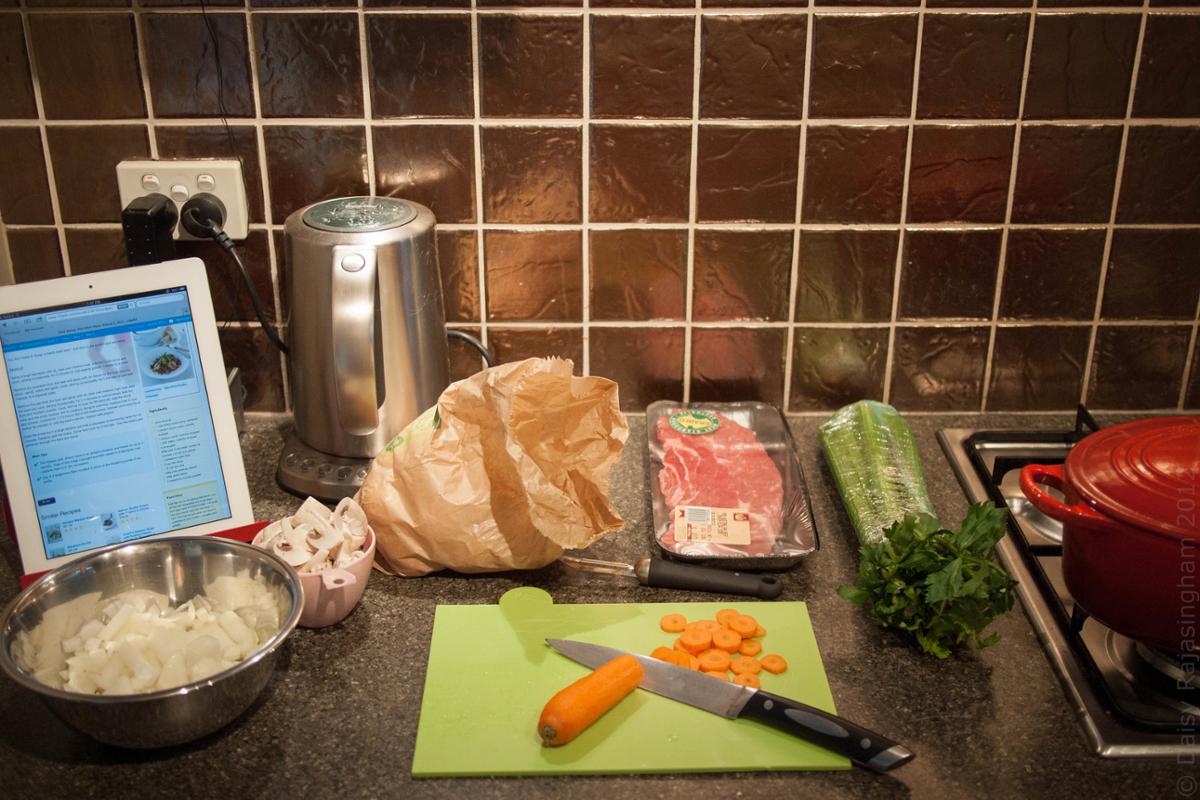 Vegetable and meat ingredients set up in a kitchen for cooking prep