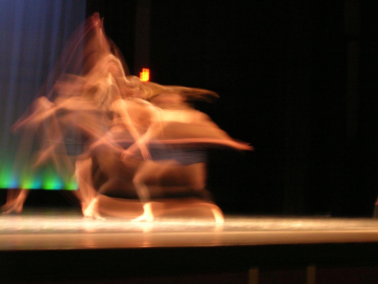 The motion blur left behind as a dancer practices on stage in a variety of poses