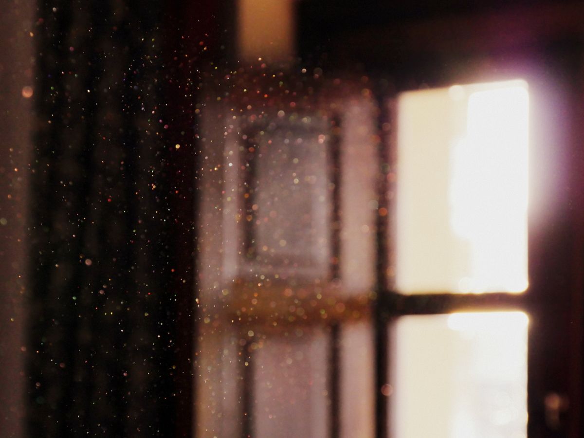 Dust particles in the air seen from the light of a window in a wooden wall