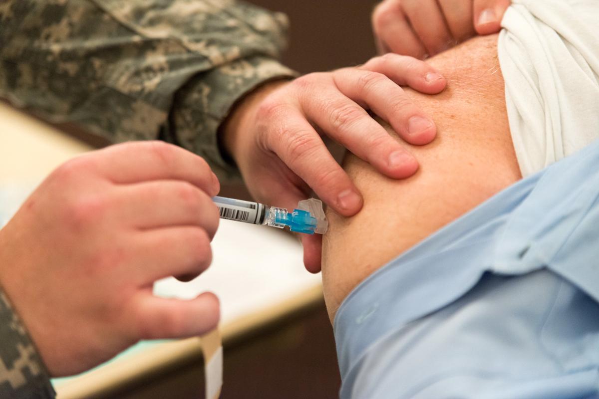 A close up of a patient's arm while receiving a flu shot
