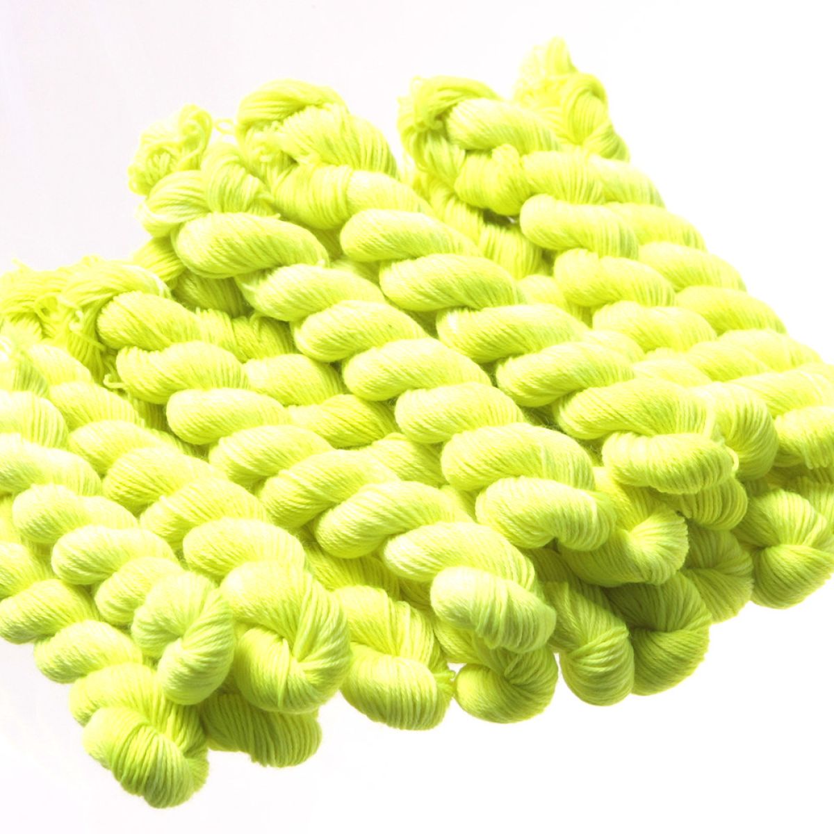 Very bright fluorescent yellow clothing fiber wound together in bundles against a white background
