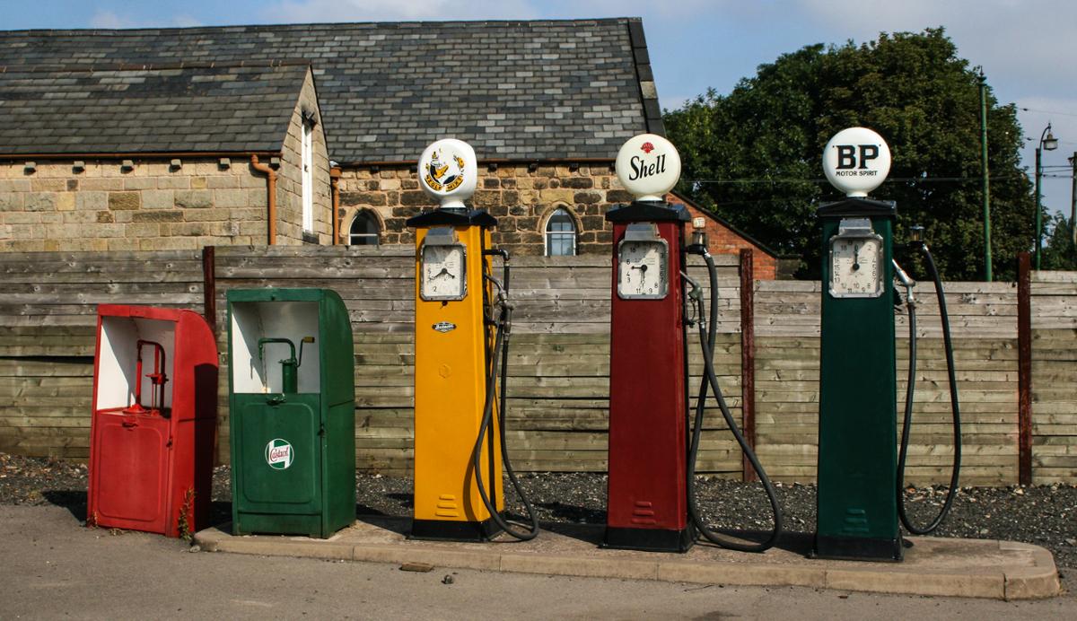 A line of old-fashioned, colorful gas pumps on a sunny day
