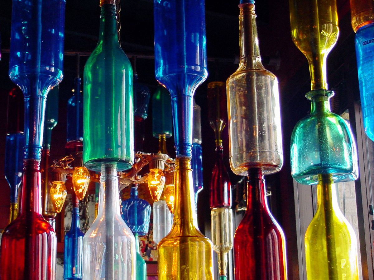 Glass bottles stacked on top of each other in towers, all in various colors and shapes