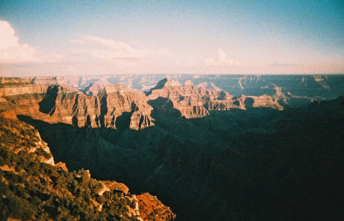 A view of the Grand Canyon on a sunny day, with big clouds in the distance