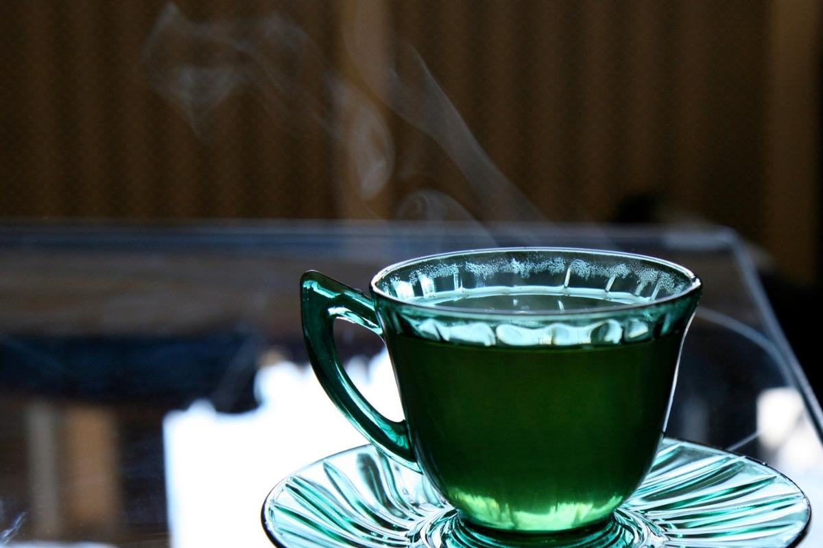 A cup of hot tea in a translucent green teacup