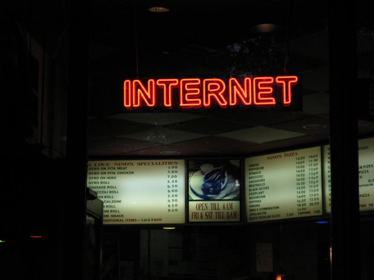 A red neon sign in a cafe that says "internet"