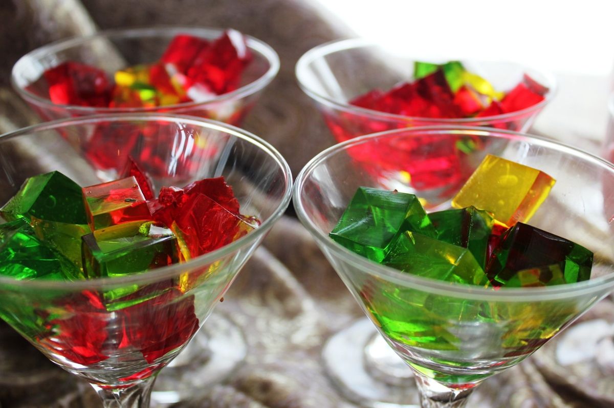 Cubes of multicolored jello sit in martini glasses