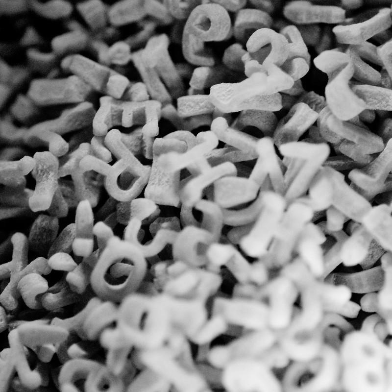A black and white photo of a jumble of letters together in a large pile