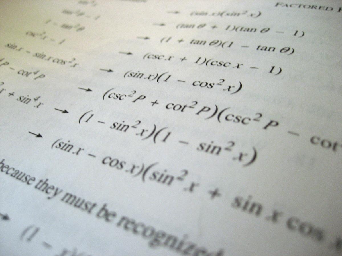 A closeup of a page from a math textbook with various equations to solve