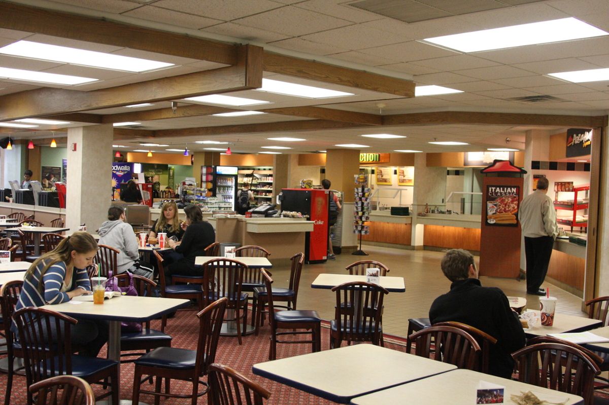 Inside the Indiana Memorial Union cafeteria, with several tables and chairs and people getting lunch