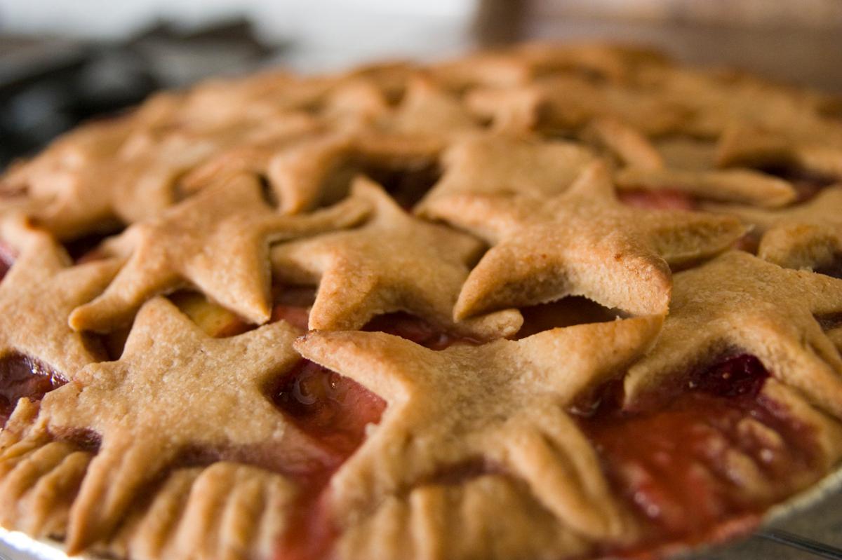 A close up of a fruit pie with stars cut out of crust on top