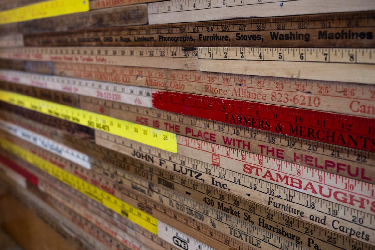 A wall display showing a variety of rulers with various hardware logos