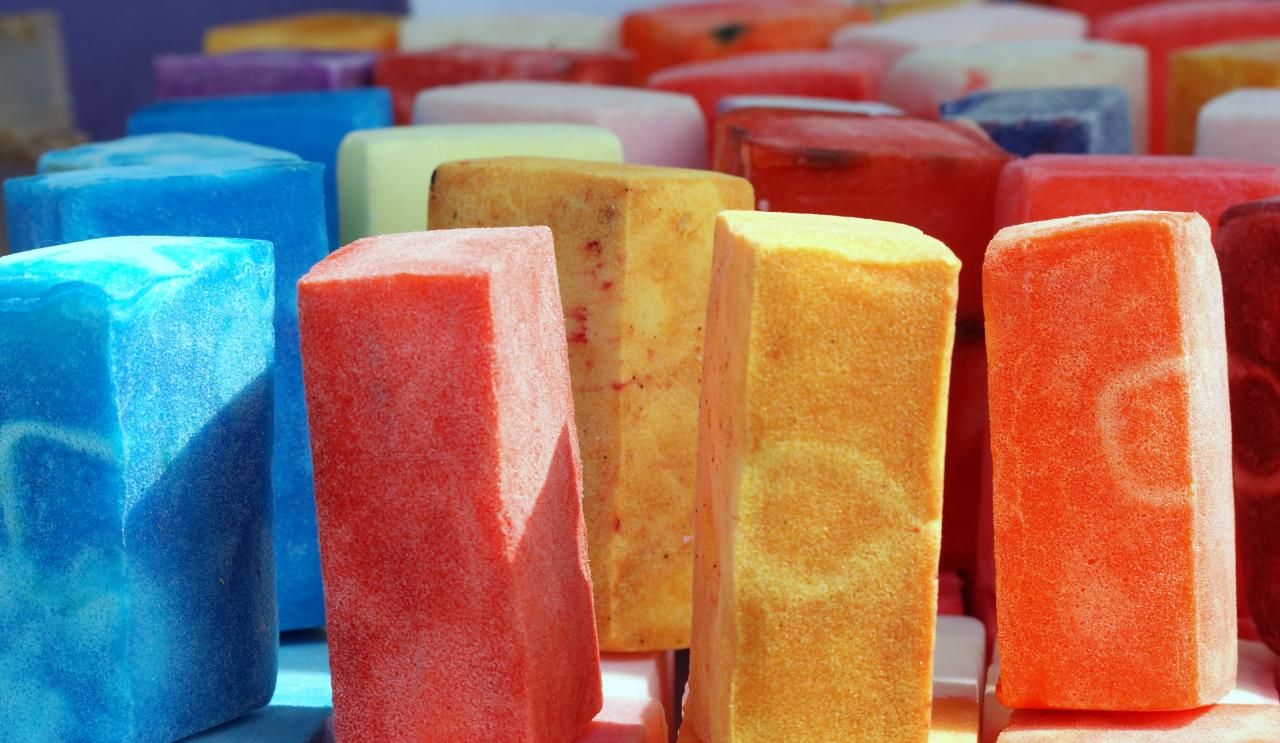 Blocks of colorful, handmade soap stand together on a table display