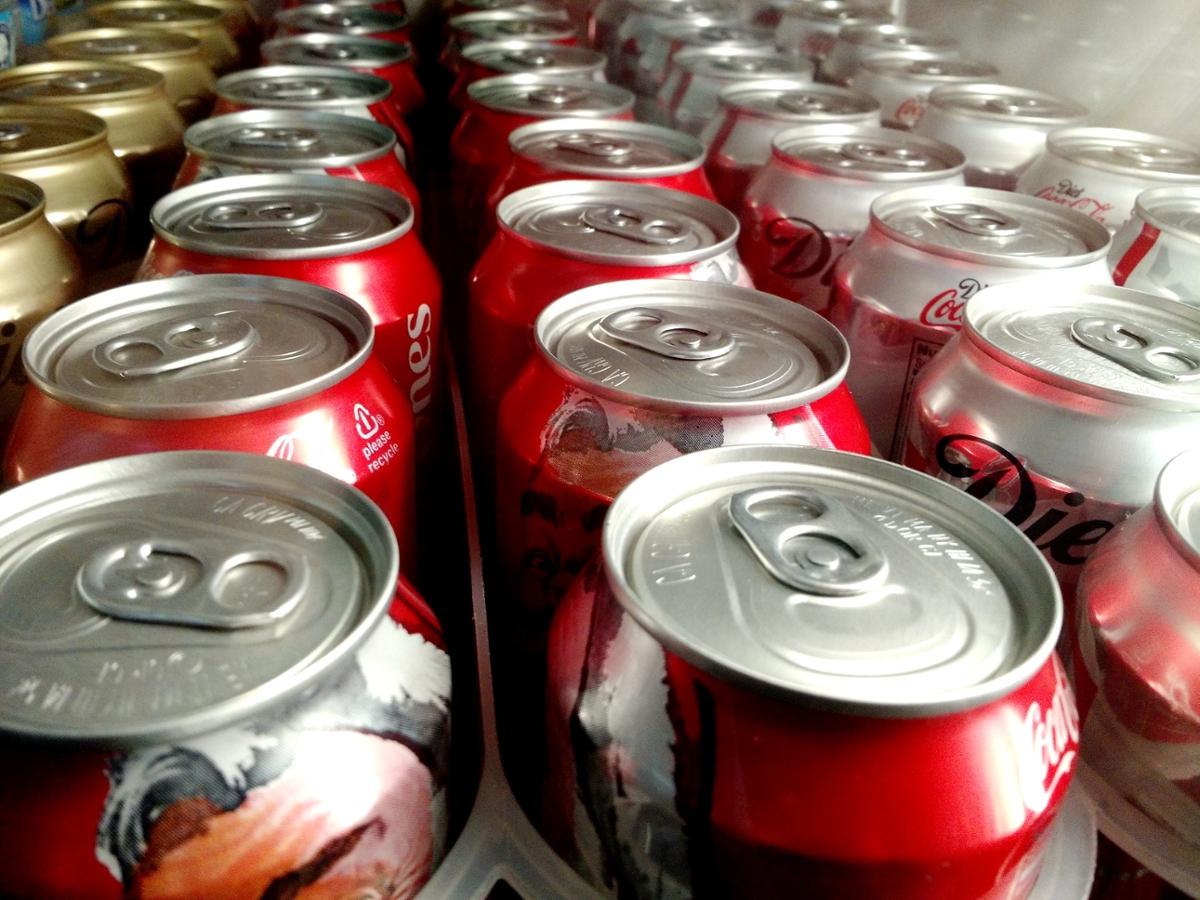 Several cans of soda standing in multiple lines