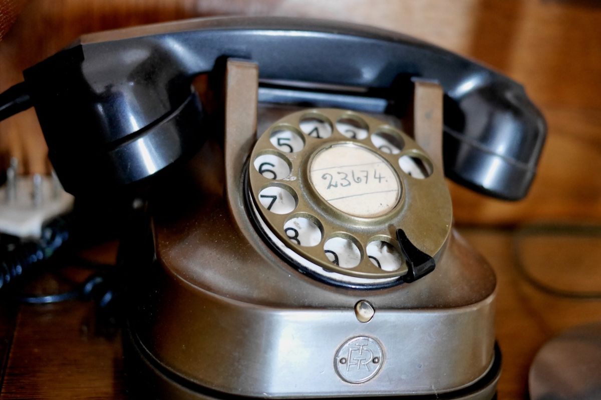 An older black telephone with rotary dial