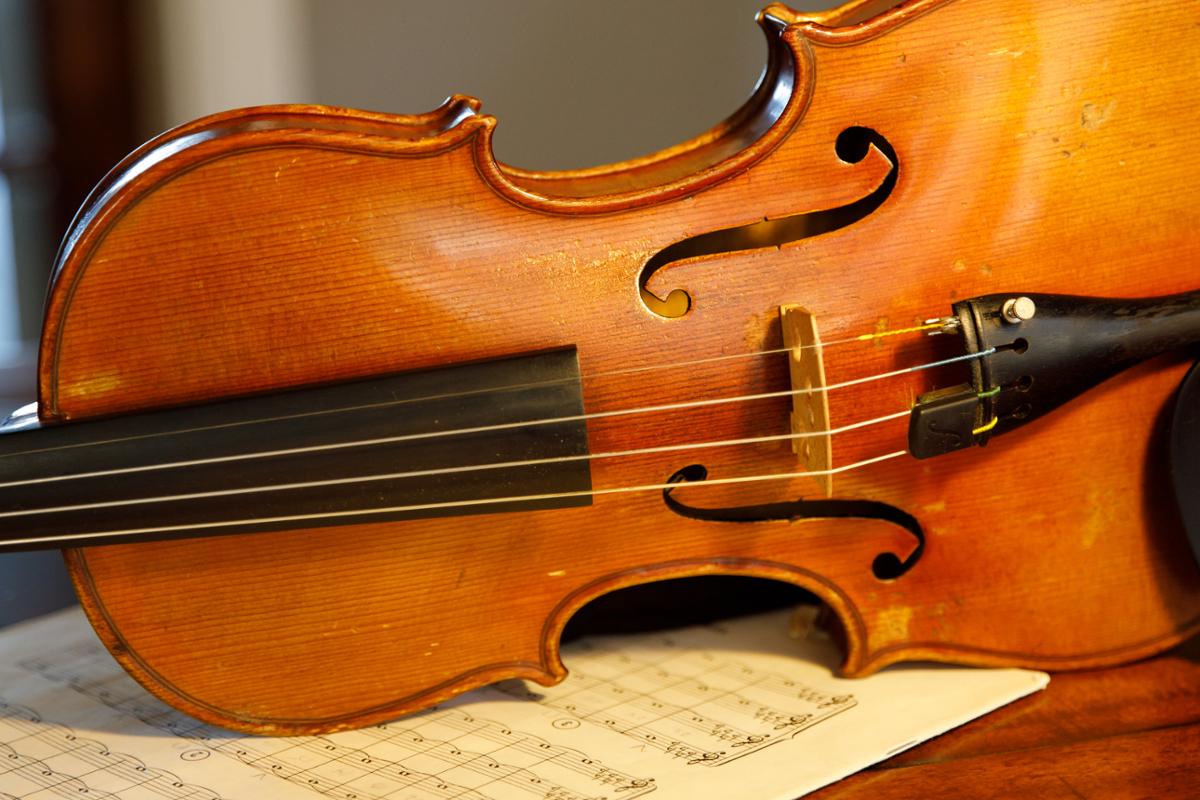 A closeup of a violin on its side on top of sheet music