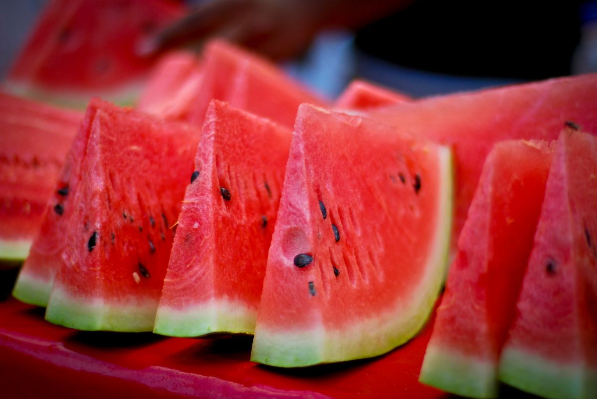 Several large slices of watermelon standing next to each other