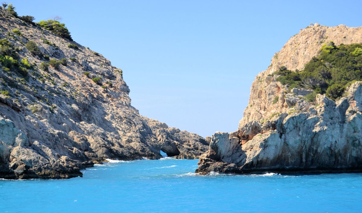 The white, rocky coast of Zakynthos, with bright blue water on a clear sunny day