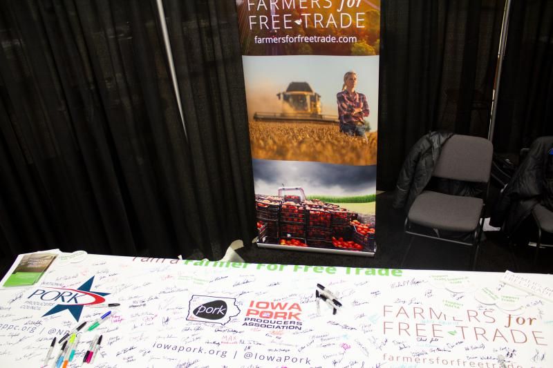 A display at a table at a farm trade show. Many signatures and a sharpie on a banner on the table, with logos of companies.