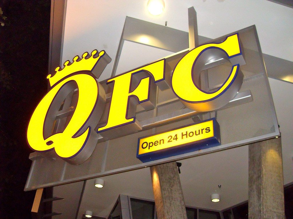 Large yellow sign with the letters Q-F-C, with a crown on the Q