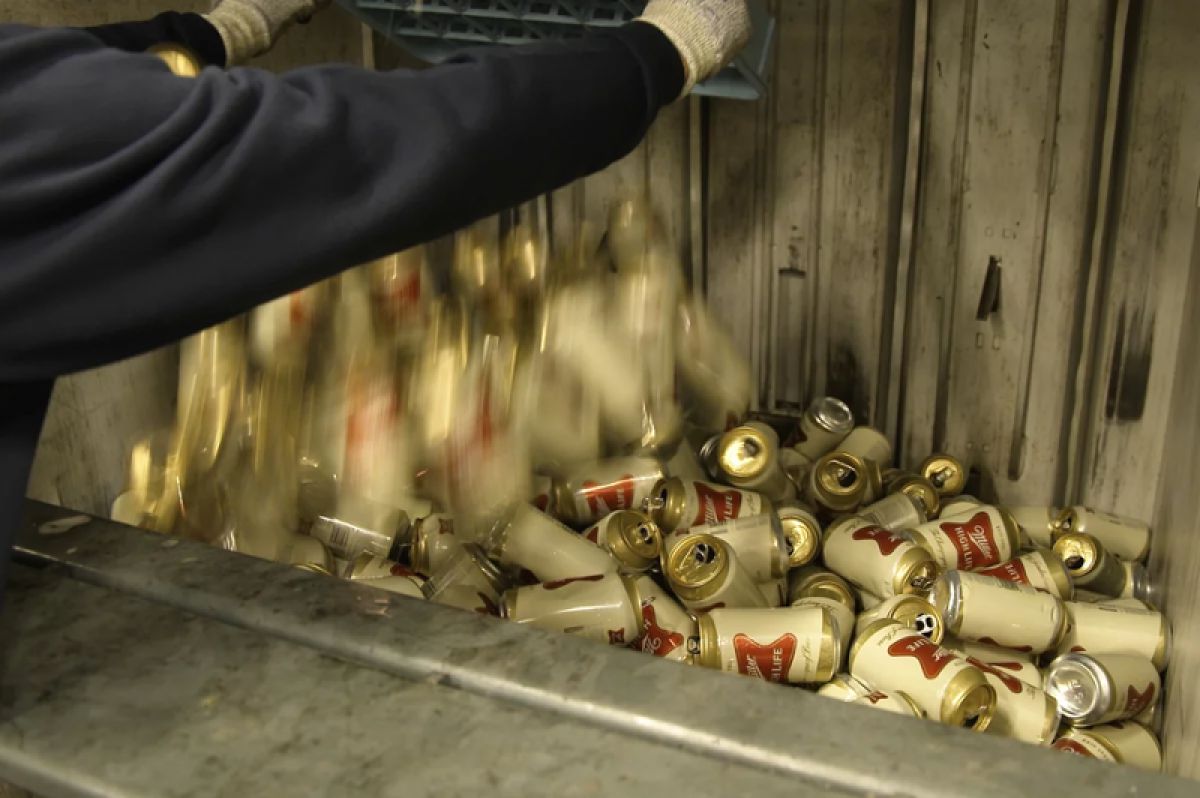 Cans of Miller High Lite being crushed