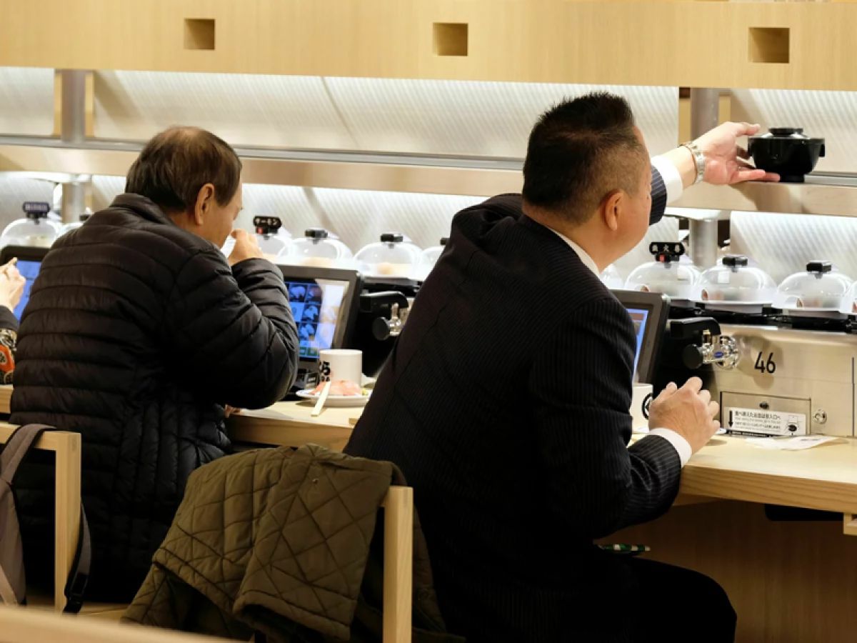 Customers eating at a conveyor belt sushi restaurant 