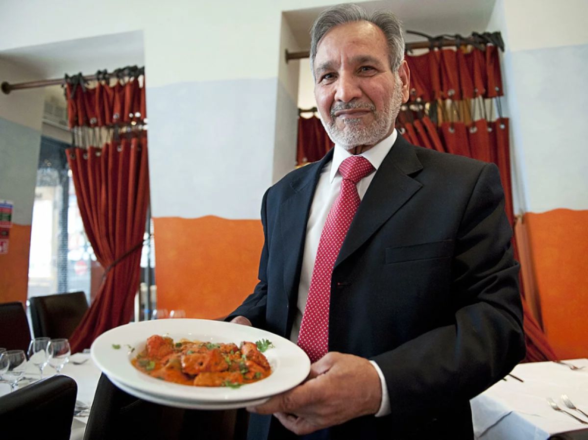 Ahmed Aslam Ali with a plate of chicken tikka masala