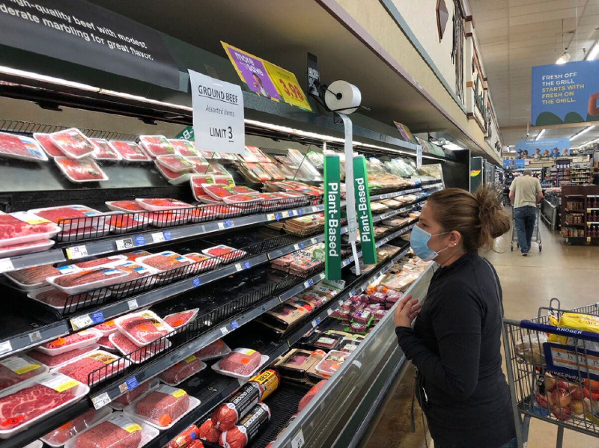A women in the ground beef section of a supermarket