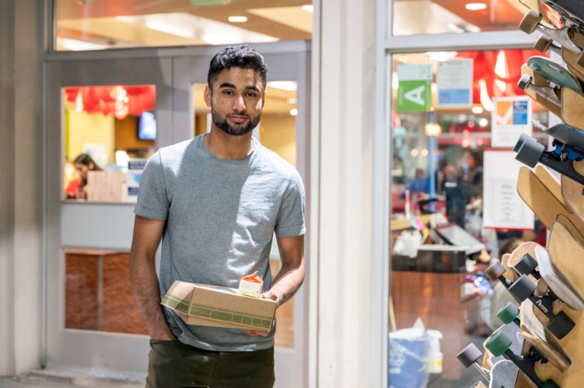 Talha Rafique with a to go box from a dining hall