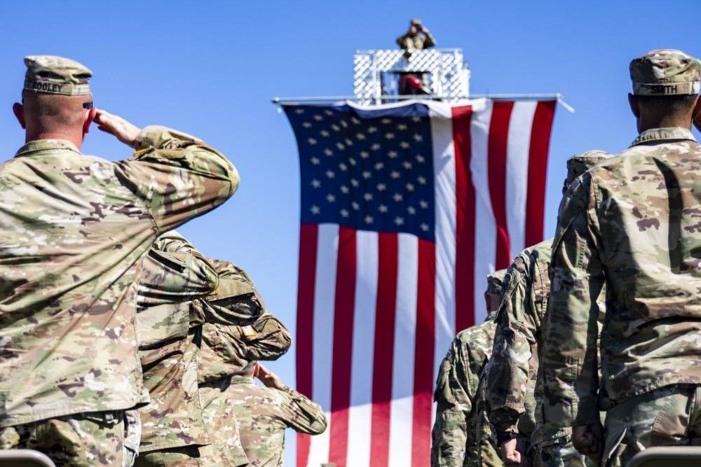 Soldiers with the 76th Infantry Brigade Combat Team salute the U.S. flag during the national anthem during their departure ceremony at Camp Atterbury near Edinburgh, Friday, Sept. 30, 2022.