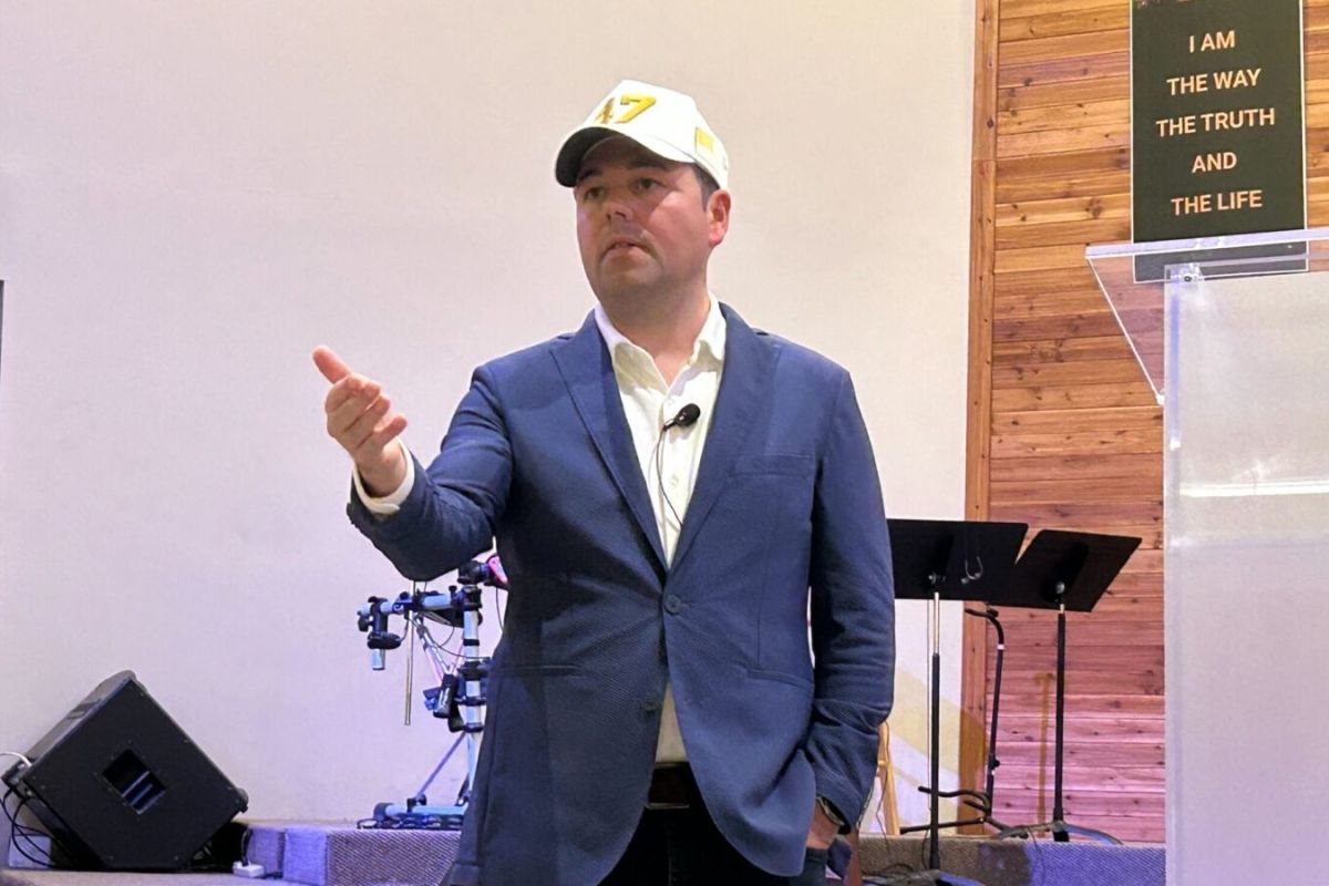 Micah Beckwith, wearing a blue suit jacket and white and yellow ballcap