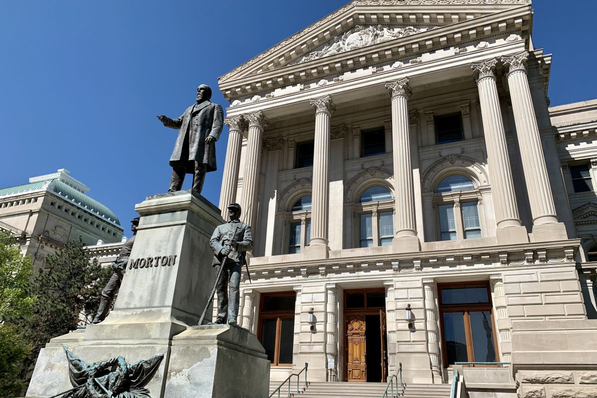 The eastern exterior of the Indiana Statehouse. A statute of former Governor Oliver Morton stands in front of the building.