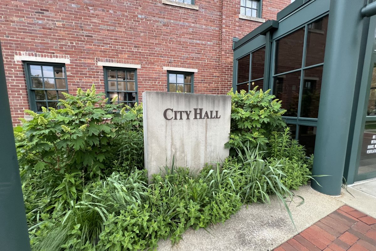 Concrete sign displaying the words "City Hall" outside of Bloomington's city hall and government center.