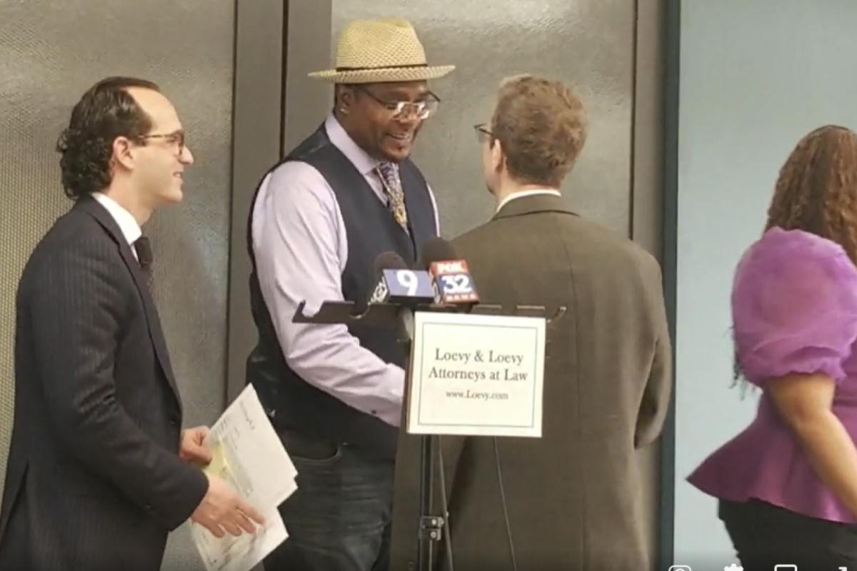 Keith Cooper (center) shakes hands with his attorneys after a press conference in Chicago on Wednesday, May 4.